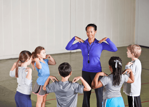 The physical education teacher supervises and guides students during a physical training session, promoting fitness and teamwork.