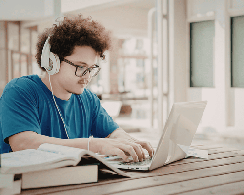 A person studying for the Arkansas Real Estate Salesperson exam on a laptop